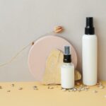 Spray-pump fragrance and body spray bottles styled with natural stone and pebbles, representing OEM body spray and fragrance mist manufacturing in Malaysia