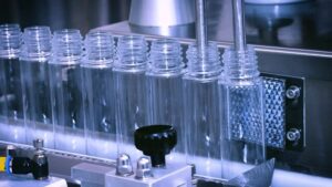 Empty plastic bottles moving along an industrial filling line, representing OEM/ODM home care and household cleaning product manufacturing in China