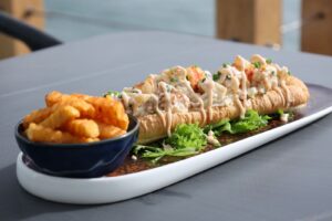 Lobster roll with crinkle-cut fries on a white plate, illustrating InNature's acquisition of the Burger & Lobster franchise in Malaysia