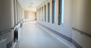 Bright, empty private hospital corridor with large windows and handrails, illustrating GIC's investment in Malaysian hospital operator Sunway Healthcare