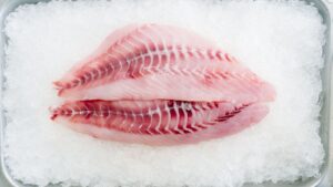 Fresh white fish fillets on crushed ice, illustrating Vietnam's pangasius fillet export industry led by Vinh Hoan